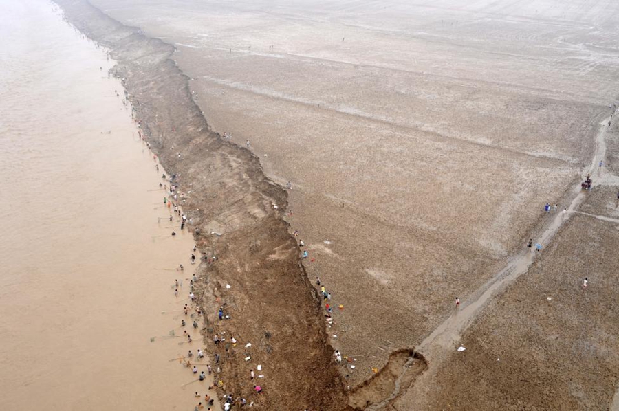 دریائے زرد سے گزرنے والے سیلابی ریلے میں لوگوں کی بڑی تعداد مچھلیاں پکڑتی ہوئی۔ صوبہ شان سی 