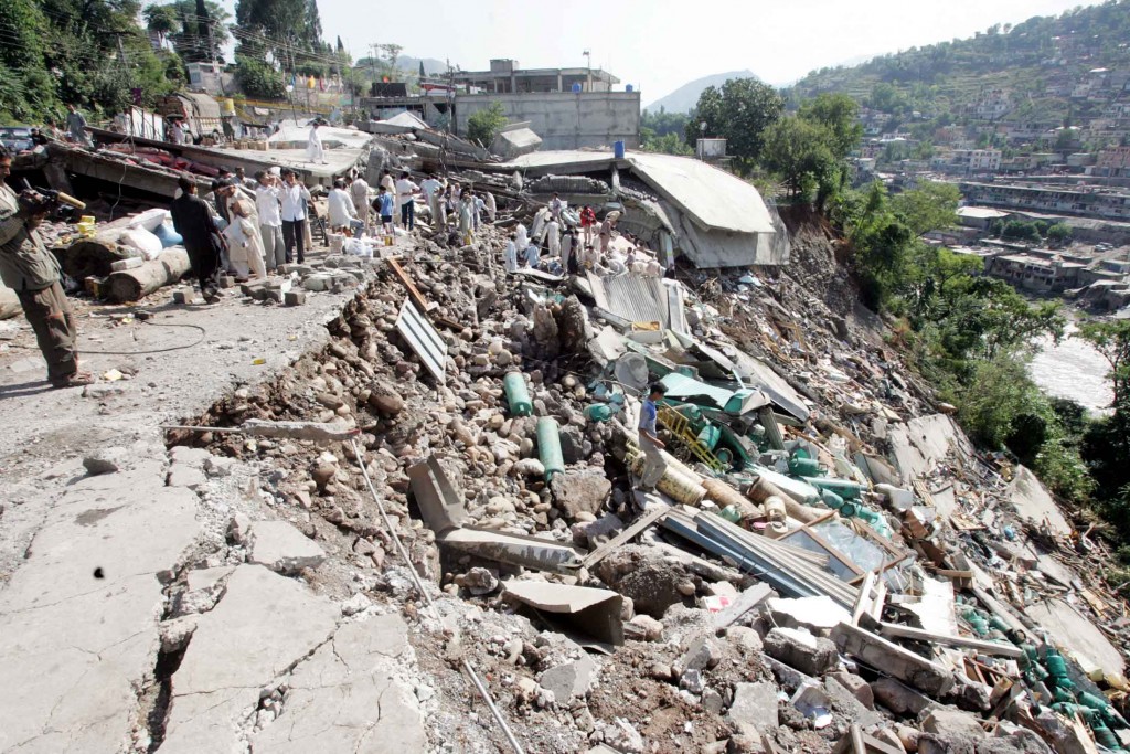 Pakistani rescue workers gather at the site of a building collapse in Muzaffarabad
