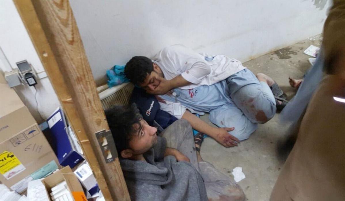 قندوز میں ڈاکٹرز وِد آؤٹ بارڈر کے کلینک پر حملے کے بعد عملے کے چند زخمی اراکین زمین پر بیٹھے ہوئے ہیں۔ واقعے میں عملے کے 9 اراکین جاں بحق ہوئے 