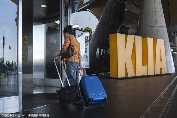 ایک خاتون مسافر کوالالمپور کے بین الاقوامی ہوائی اڈے کے روانگی لاؤنج میں داخل ہوتے ہوئے 