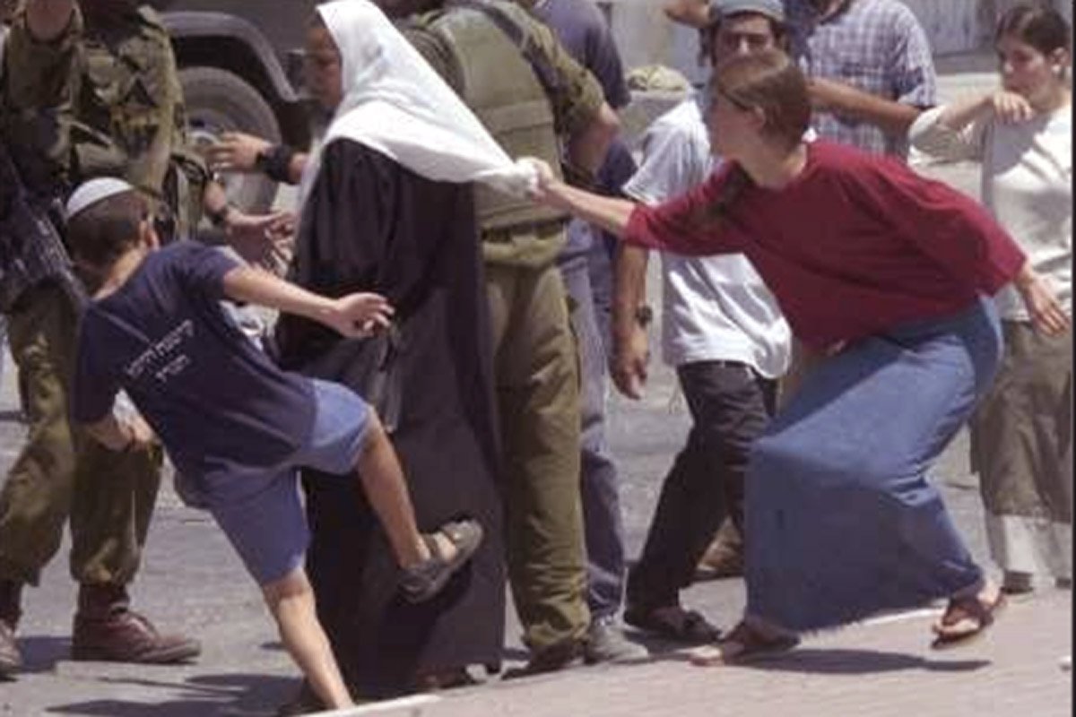 اسرائیل کے یہودی آبادکار ایک فلسطینی خاتون پر حملہ کرتے ہوئے 